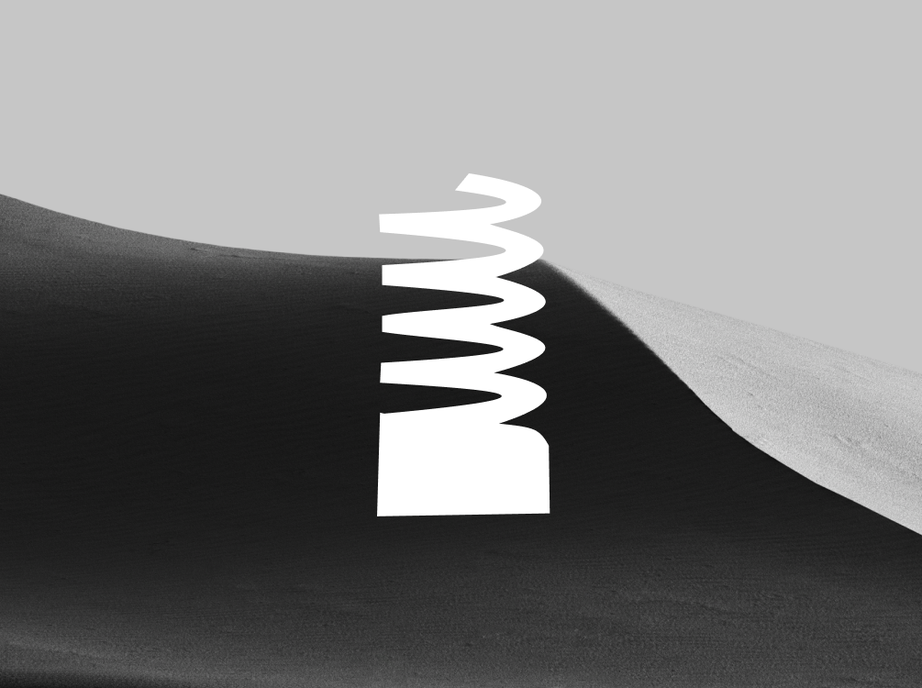 The Webby Awards coiled spring trophy in white over a black and white sand dune.