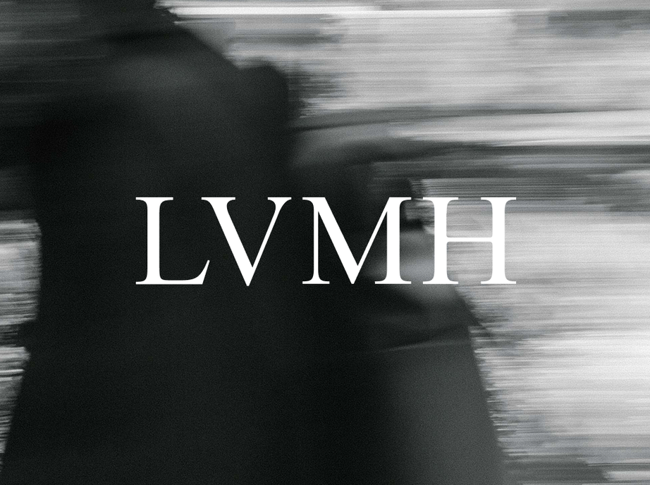 LVMH wordmark in white over a motion-blurred black and white photo of a person walking.