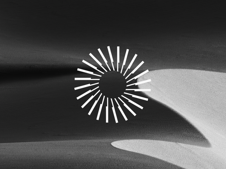 Hut 8’s turbine mark in white over black and white sand dunes.