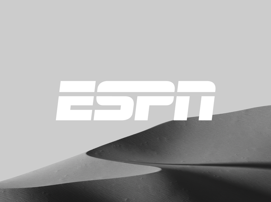 ESPN logo in white over a black and white photo of soft sand dunes.