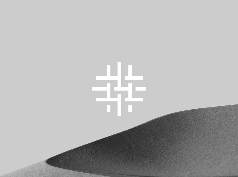 Urban Partners logo, a white interlocking grid symbol, over a grey sky and a black and white sand dune.