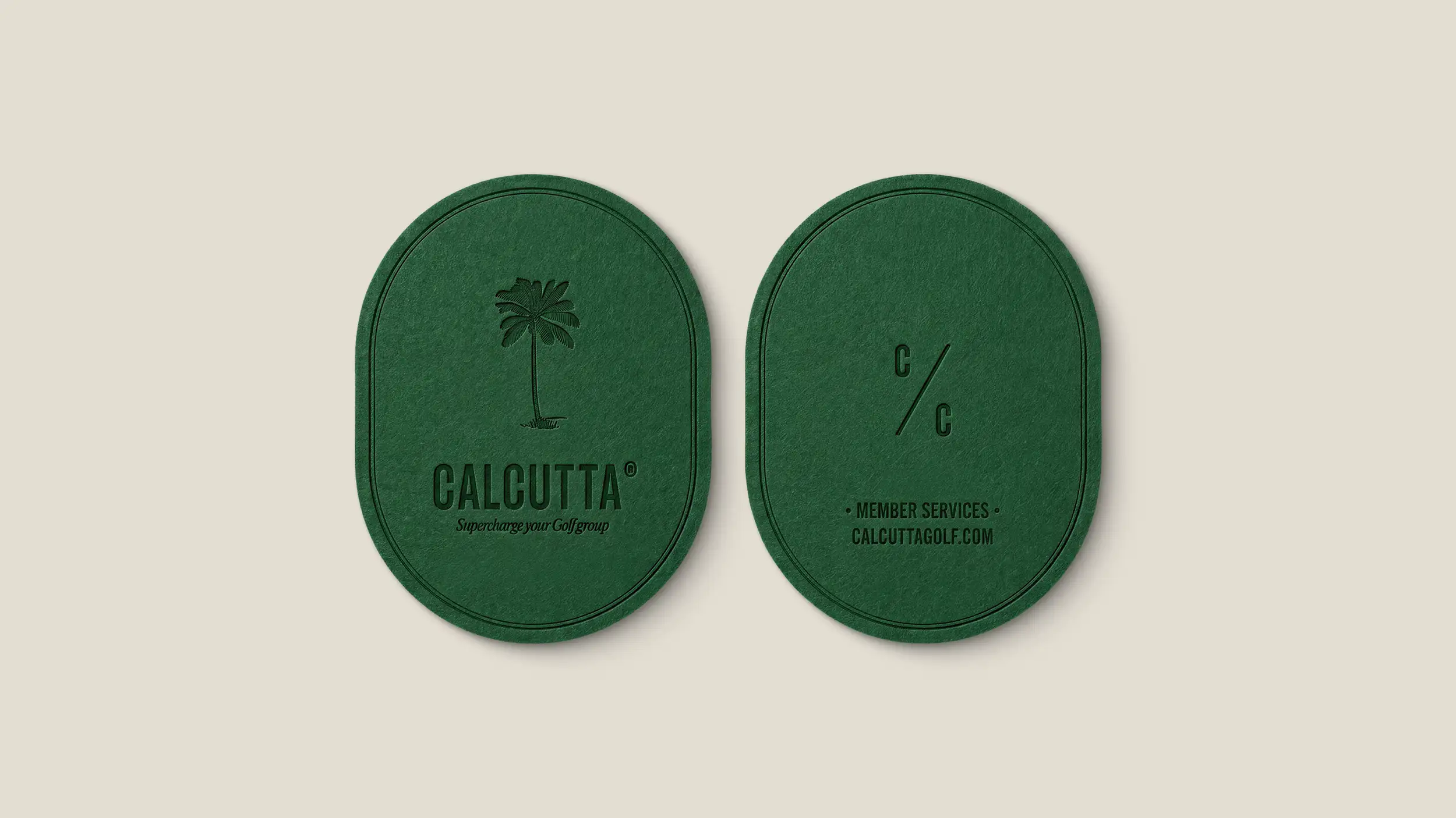 Two oval forest-green coasters (or branded cards) shown front and back on a cream background, with subtle embossed/debossed detailing. The left coaster features an illustrated palm tree above the "CALCUTTA®" wordmark and the tagline "Supercharge your Golf group." The right coaster shows the "C/C" monogram (two C's split by a diagonal slash) above the text "• MEMBER SERVICES • CALCUTTAGOLF.COM." The tonal green-on-green printing gives an elegant, premium finish.