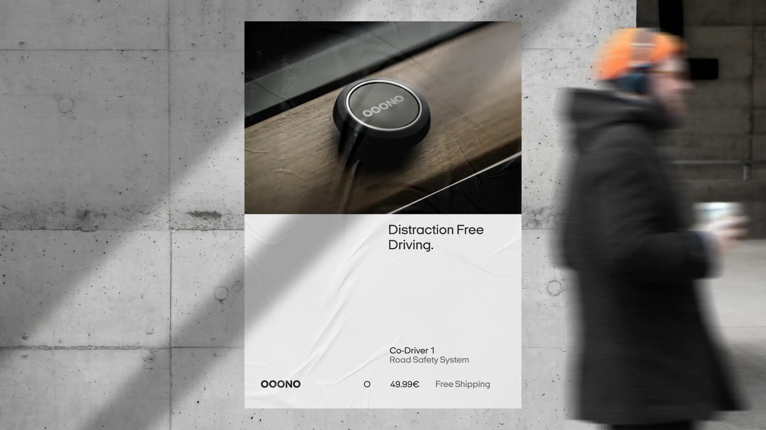A wheatpasted OOONO advertising poster mounted on a raw concrete wall, with diagonal sunlight falling across it. The top half of the poster is a close-up photo of the black circular OOONO Co-Driver device resting on a wooden surface. The bottom half is white and carries the tagline "Distraction Free Driving." in large black type, with "Co-Driver 1 — Road Safety System" below it. Along the bottom, the "OOONO" wordmark appears beside a small circular "O" icon, the price "49.99€," and "Free Shipping." On the right side of the frame, a pedestrian in a dark coat and orange knit hat walks past, blurred by motion.