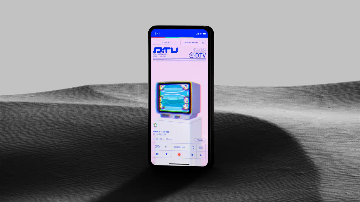 Smartphone mockup standing upright on a gray sand dune background, displaying the D.TV interface, described as 'Built on Lens®.' The screen shows a top bar with TV GUIDE and a connected DAVIDs WALLET, the D.TV logo with '24HRS ALL YEAR,' and the current time 12:09. Below, a glitch-effect illustration of a retro CRT television with a glowing blue screen sits on a white pedestal, framed by a pink gradient background. Under it, placeholder video info reads 'Name of Video BY @CREATOR' with a progress bar at 02:03/03:44, a FOLLOW button, and a row of icons for comments, view count, 'CHANNEL 05,' and a menu, plus playback controls at the bottom.