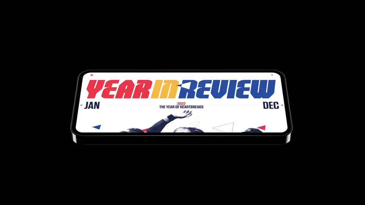 Smartphone displaying "Year In Review 2022: The Year of Heartbreaks," with vibrant red, yellow, and blue text.