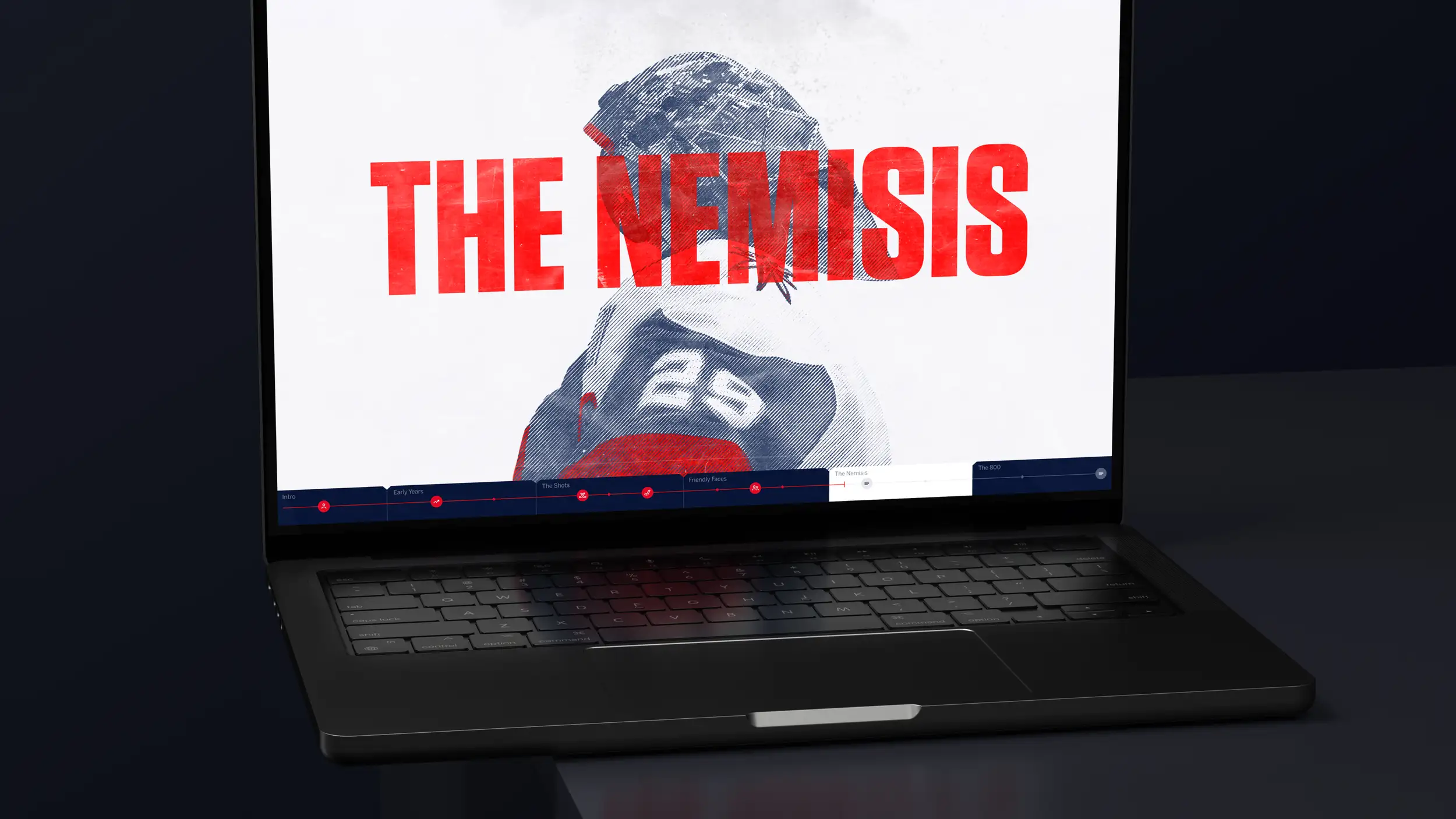 An open laptop shown at a dramatic angle on a dark surface, displaying a chapter screen from the "OVECHKIN 800" hockey feature. The screen shows a large, halftone/duotone treated photo of a hockey player (in a red-and-white Capitals jersey, number 8) set against a white background, overlaid with the bold red title "THE NEMISIS." A horizontal chapter-navigation timeline runs across the bottom of the screen with labeled sections: Intro, Early Years, The Shots, Friendly Faces, The Nemisis (currently active), and The 800, each marked with red icons and progress dots. The laptop's dark backlit keyboard and trackpad are visible in the foreground.