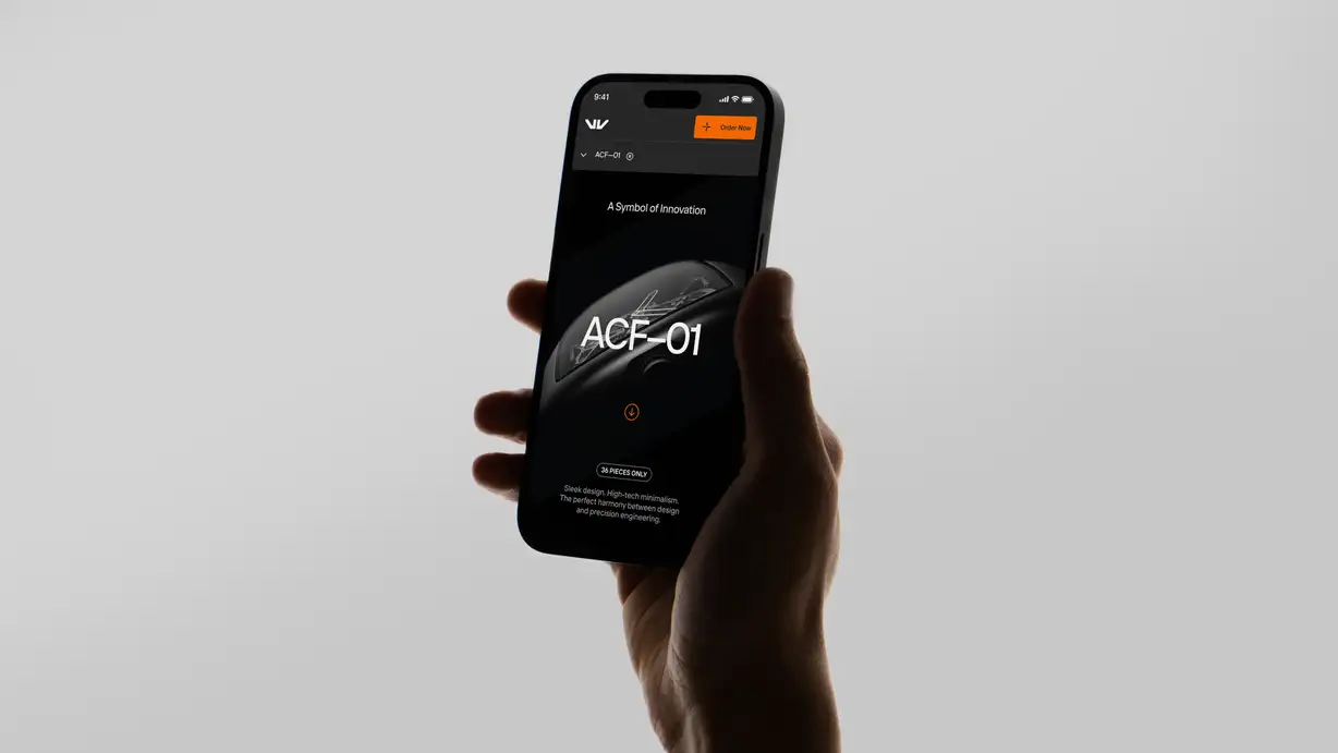 A hand holds up a smartphone against a plain light gray background, displaying a sleek, dark-themed product website for a limited-edition item called "ACF-01." The status bar reads 9:41. The top navigation shows an angular white "W"-style logo on the left and an orange "+ Order Now" button on the right, with a "ACF-01" label bar below. The hero screen, on a black background, reads "A Symbol of Innovation" above the large white product name "ACF-01" overlaid on a dark, glossy render of the sculptural product. Below, an orange down-arrow scroll button, a "36 PIECES ONLY" pill badge, and body text reading "Sleek design. High-tech minimalism. The perfect harmony between design and precision engineering."
