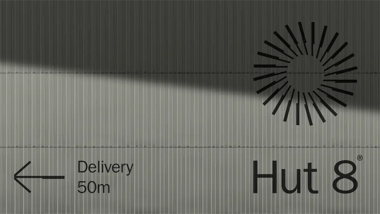 Close-up of a corrugated metal building wall with a black sunburst logo, a "Delivery 50m" directional sign, and the "Hut 8®" wordmark.