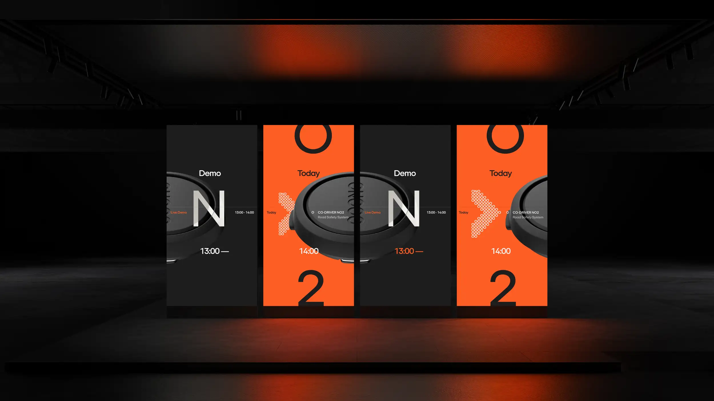 A dark showroom installation with four tall vertical LED panels alternating black and orange, displaying a black circular device alongside text like "Demo," "Today," "CO-DRIVER NO2 Road Safety System," time stamps "13:00–14:00," and large numerals, under warm orange ambient lighting.